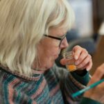 an older woman holding a glass of liquid
