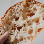 a close up of a person holding a piece of bread