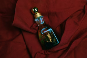 A bottle of liquid sitting on top of a red cloth