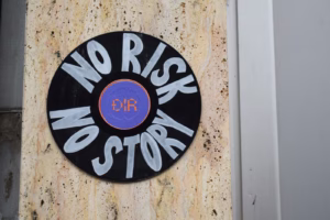 Round sign with "no risk no story" text