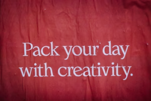 a red surface with white text saying, "Pack your day with creativity". 
